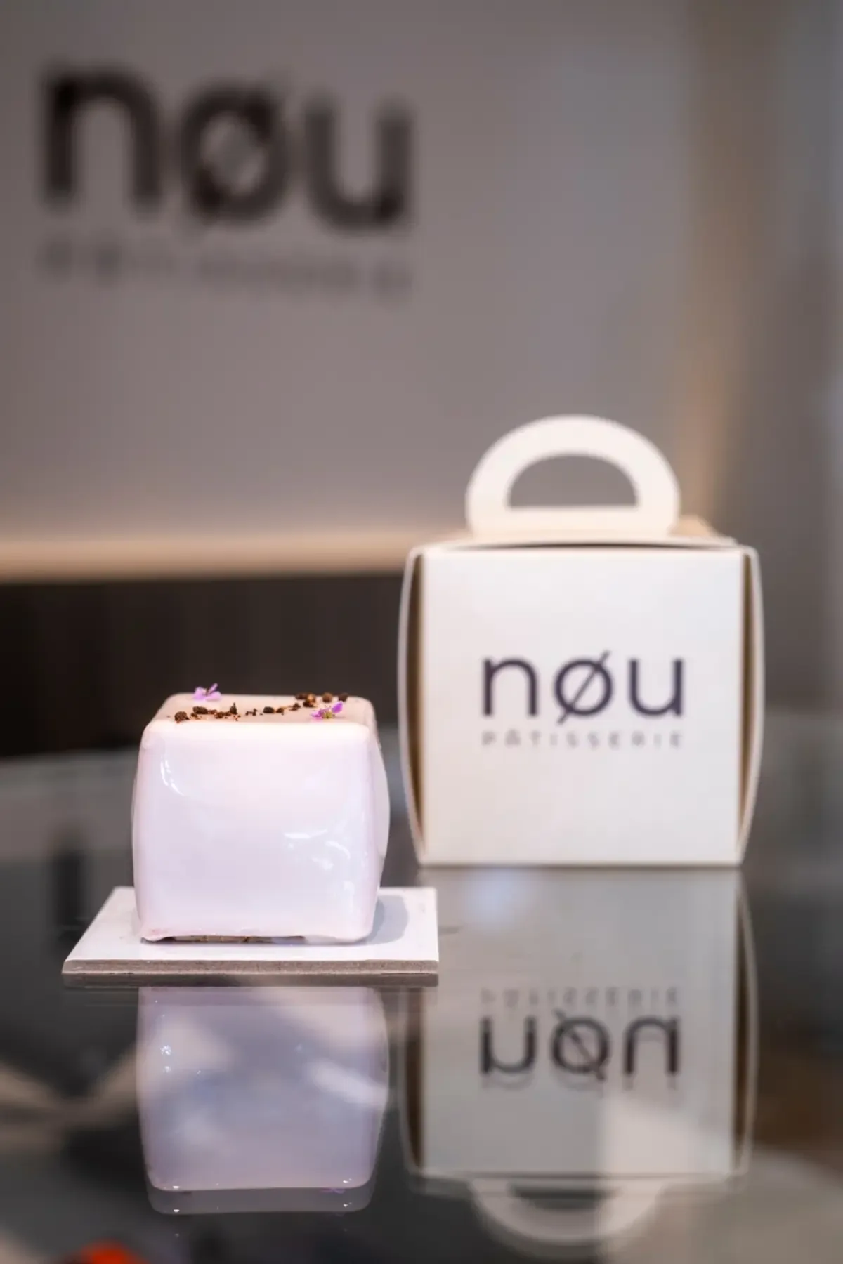 Entremets rosa-claro e caixa nøu, fotografados no atelier